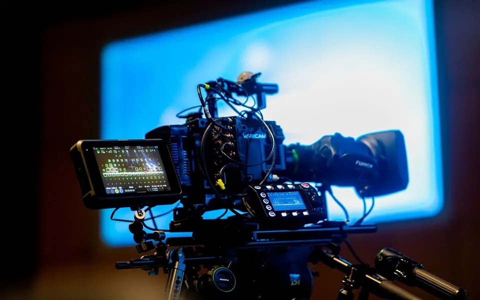 Mavi sinematik ışık önünde profesyonel sinema kamerası düzeneği