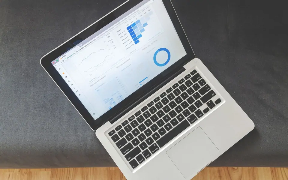 Masadaki dizüstü bilgisayar ekranında analitik grafikler ve veri panosu